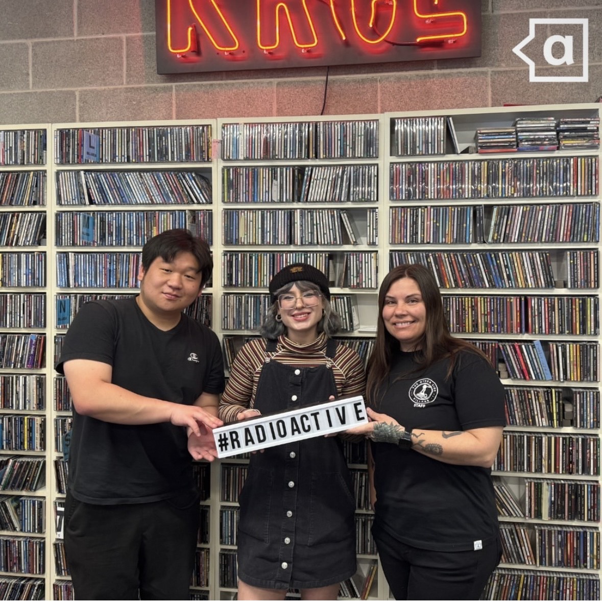 Jae, Jordyn, and Tiffany stand with CD wall