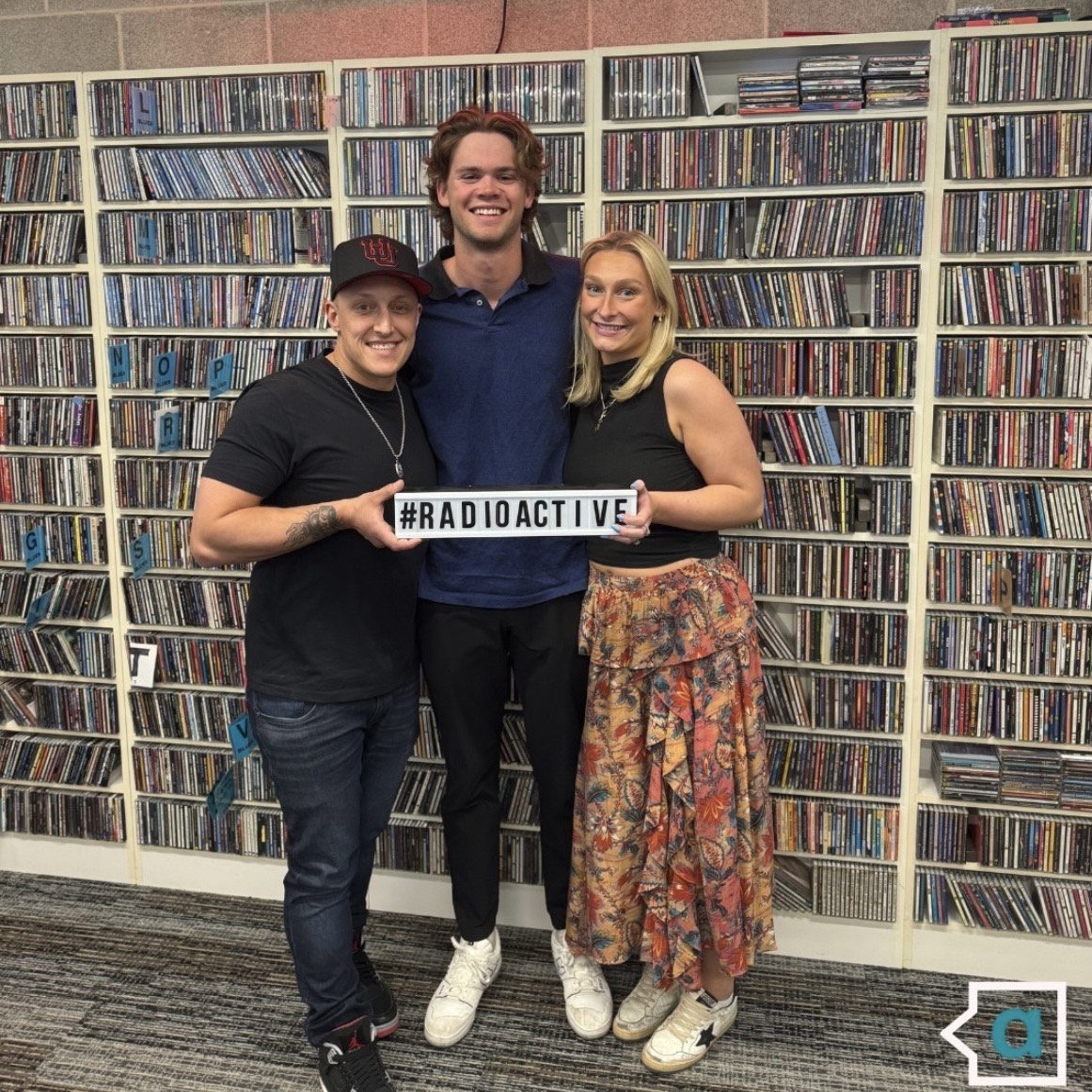 Clay, Malcolm, and Kate stand with CD wall