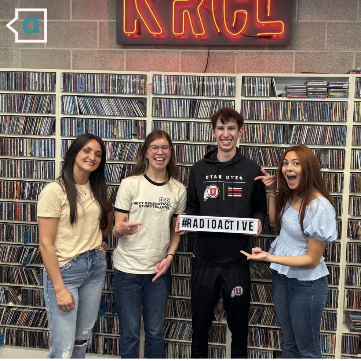 Tori, Sofia, Zach, and Nathalia stand in front of CD wall