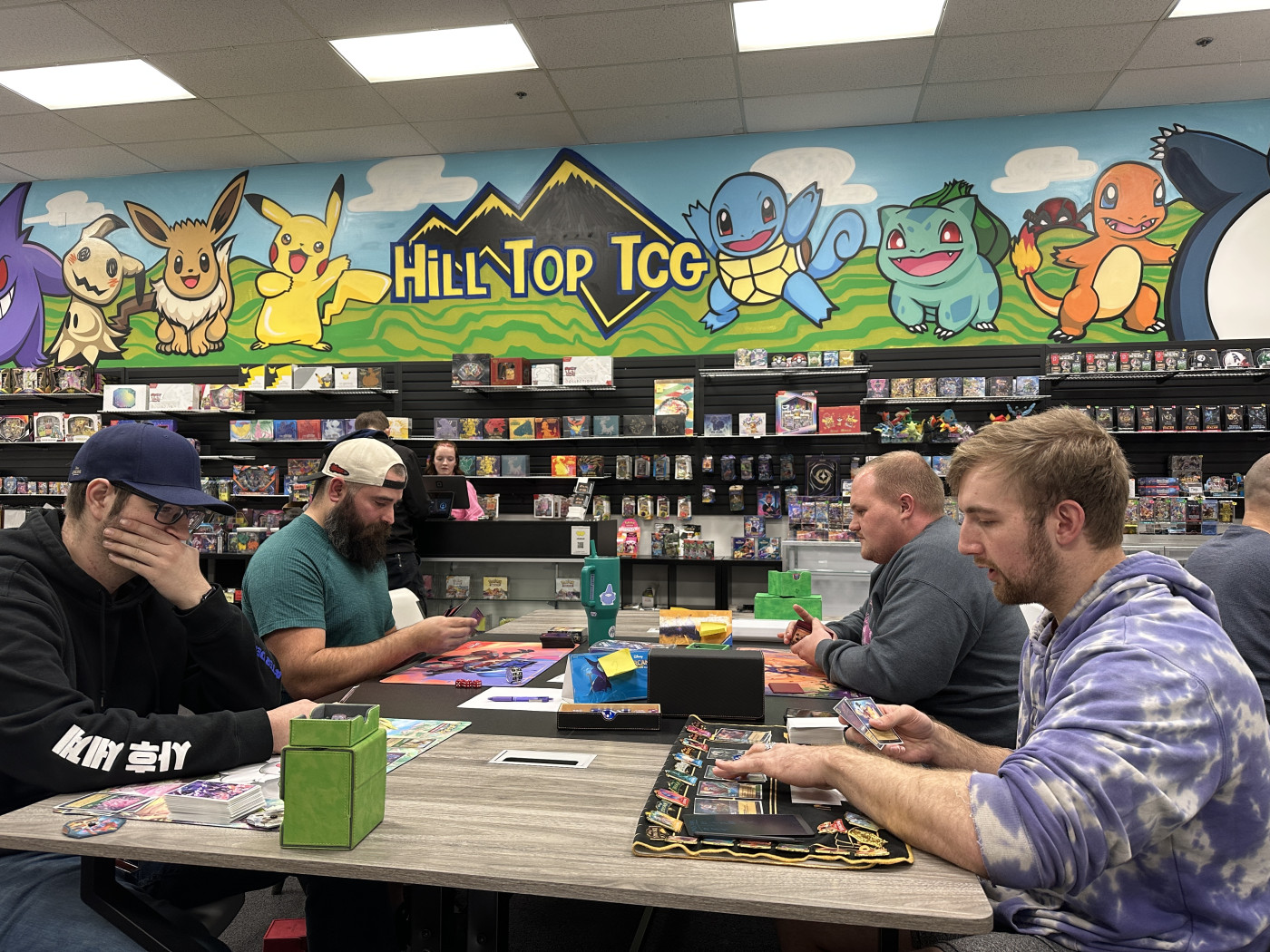 Lorcana enthusiasts engage in a heated game during a community league night at Hill Top TCG in Riverdale, Utah.