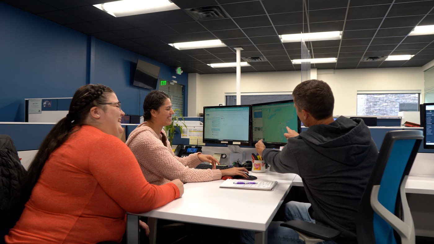 Amy (left), Melissa (middle), and Mike (right) working together to resolve a shipping issue